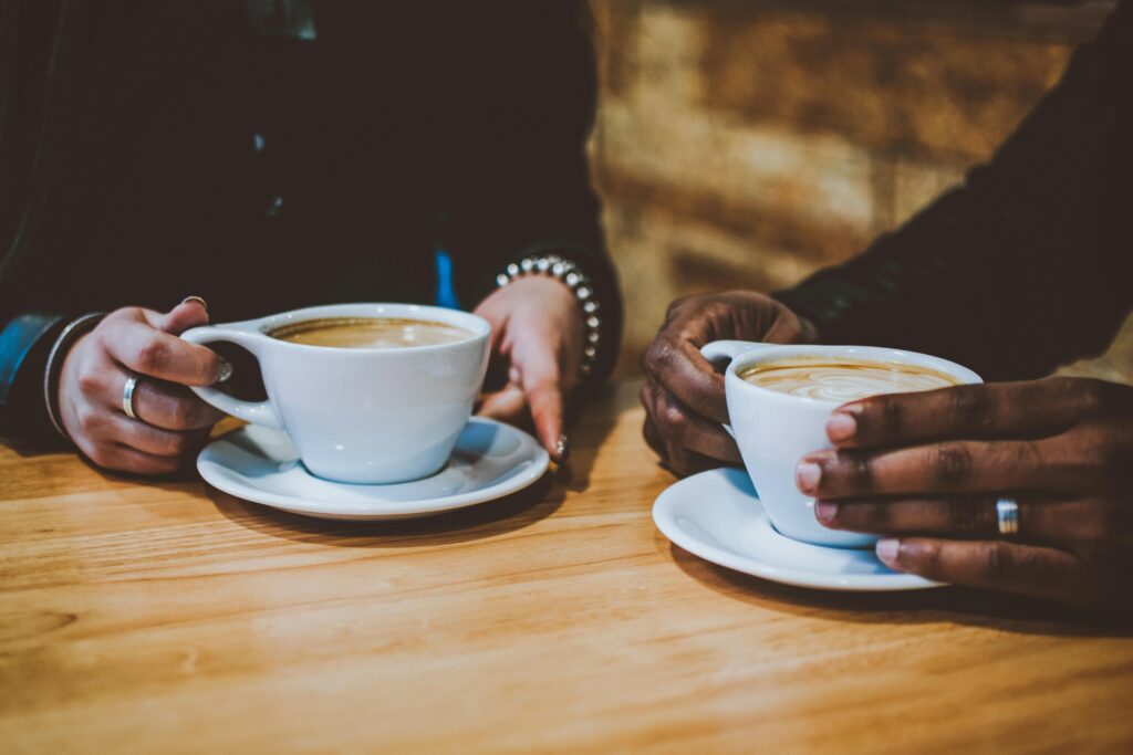 two people holding cappuccinos as an analogy for online forums in creating web design for social change. 